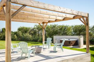a wooden pergola with chairs and a table and a hot tub at La Villa Mirau in Cavaillon