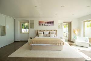 a white bedroom with a large bed and a white chair at La Villa Mirau in Cavaillon +44 photos