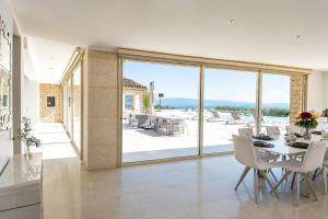 a dining room with a table and a view of a patio at La Villa Mirau in Cavaillon
