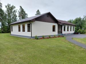 a house with a large yard in front of it at Lapsiņmuiža Pool House - Pool, Sauna & Hot-tub included in Dzedri