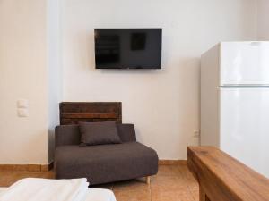 a living room with a couch and a refrigerator at Sofia Apartments- Melidoni in Melidhónion
