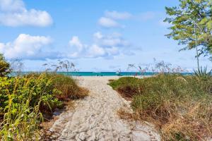 a sandy path leading to a beach with the ocean at Playa Casanas South in Holmes Beach