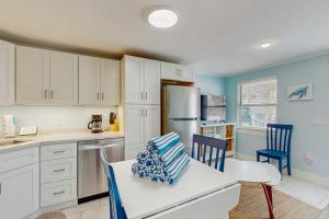 a kitchen with white cabinets and blue walls at Playa Casanas South in Holmes Beach
