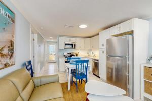 a kitchen and living room with a couch and a refrigerator at Playa Casanas South in Holmes Beach