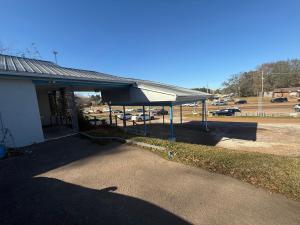 a building with awning next to a parking lot at Terrace Motel in Natchez