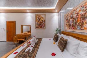 a bed in a room with a painting on the wall at Junna House Ubud in Payangan +48 photos