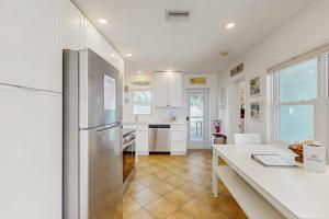 a kitchen with a refrigerator and a table in it at Sea's The Day in Anna Maria