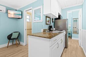 a kitchen with a sink and a refrigerator at Parrot Beach Cottages Suite #2 in Siesta Key