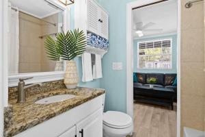 a bathroom with a sink and a toilet and a mirror at Parrot Beach Cottages Suite #2 in Siesta Key +10 photos