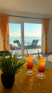 two glasses of orange juice on a table with a view at Apartments Sunset Jovanoski in Ohrid