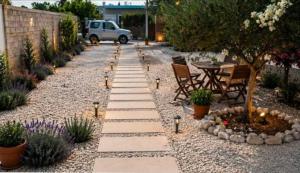 a garden with a stone pathway with a table and chairs at Casa Di Elsa, Lambi, Kos in Kos +21 photos