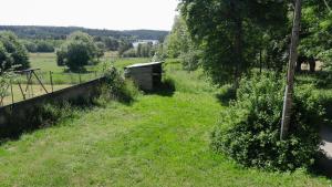a grassy field with a woodenshed in the distance at Maison rustique in Devesset