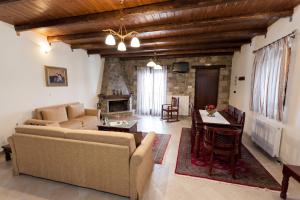 a living room with a couch and a table and a fireplace at Althaia in Ano Chora