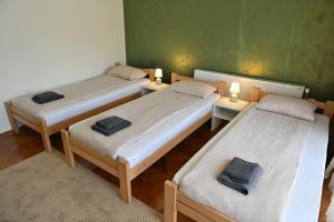 a room with three beds and two lamps on tables at Modex ROOMS in Paraćin