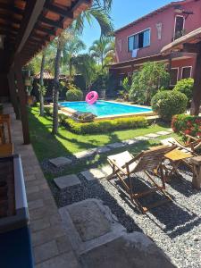 a backyard with a swimming pool with a pink frisbee at GuestHouse Casa da Aroeira in Búzios