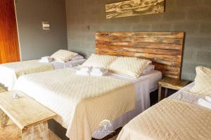 a room with three beds with white sheets at GuestHouse Casa da Aroeira in Búzios +28 photos