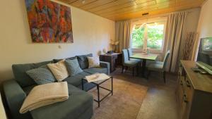 a living room with a green couch and a table at Ferienhaus Elsterblick in Bad Elster