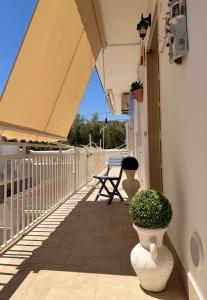 a balcony with two large white vases and a bench at Dimora Caratin' in Mattinata