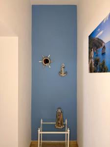 a room with a blue wall with a picture on the wall at Dimora Caratin' in Mattinata +22 photos