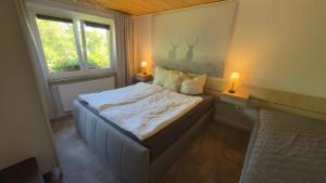 a bed in a room with two lamps and a window at Ferienhaus Elsterblick in Bad Elster