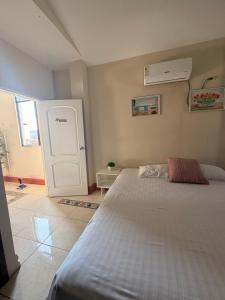 a bedroom with a large bed and a white door at Habitación Mantarraya in Manta