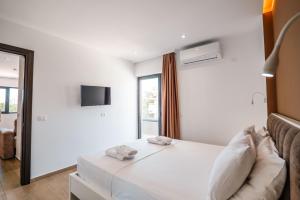 a white bedroom with a bed and a window at ADORA's VIEW HOTEL in Sarandë