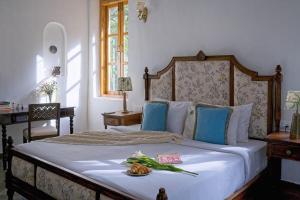 a bedroom with a large bed with blue pillows at Villa Eden 3BHK in Assagao