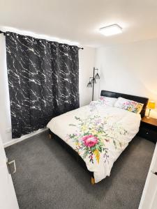 a bedroom with a bed with a floral bedspread at Beautiful Double room in Peterborough