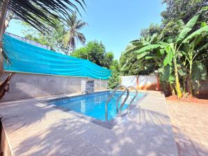 a swimming pool with a blue shade over it at Gravity Groups Core - Pannai veedu in Puducherry Airpoert