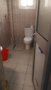 a bathroom with a toilet and a window at Royal guest home in Bonamoussadi