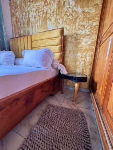 a bedroom with a wooden bed with a bench and a table at Royal guest home in Bonamoussadi