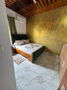 a bedroom with a bed and a yellow wall at Royal guest home in Bonamoussadi
