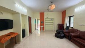 a living room with a couch and a television at Gravity Groups Core - Pannai veedu in Puducherry Airpoert