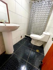 a bathroom with a sink and a toilet and a shower at La casa de Ferro in Piura