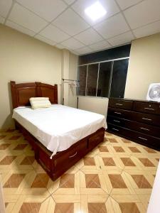 a bedroom with a large bed and a large window at La casa de Ferro in Piura
