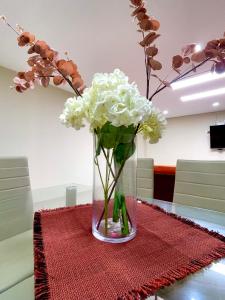 a vase filled with white flowers on a table at La casa de Ferro in Piura +3 photos