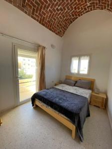 a bedroom with a bed and a brick wall at Dar Souleyman in Midoun +21 photos