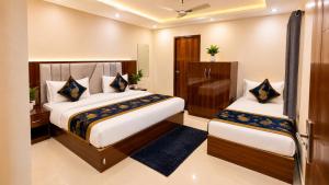 a hotel room with two beds in a room at Premium Radhe Dham Hotel & Restaurant - Fully AC - Only 5 Min Drive to Prem Mandir, Newly Build in Vrindāvan