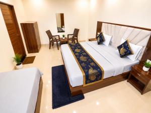 a bedroom with a large bed and chairs at Premium Radhe Dham Hotel & Restaurant - Fully AC - Only 5 Min Drive to Prem Mandir, Newly Build in Vrindāvan
