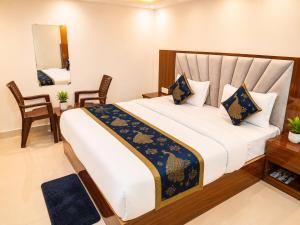 a bedroom with a large bed and a mirror at Premium Radhe Dham Hotel & Restaurant - Fully AC - Only 5 Min Drive to Prem Mandir, Newly Build in Vrindāvan