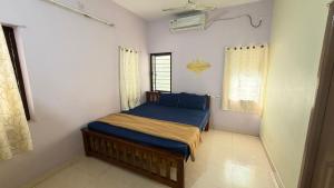 a bedroom with a bed with blue sheets and a window at Gravity Groups Core - Pannai veedu in Puducherry Airpoert +30 photos