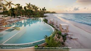 a swimming pool on the beach next to the ocean at Inna Resort & Spa in Puerto Morelos