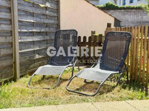 two chairs sitting in the grass next to a fence at GC - Les Flots in Wissant