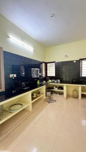 a large kitchen with black tiled walls and counters at Gravity Groups Core - Pannai veedu in Puducherry Airpoert