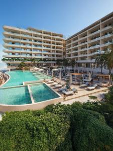 a large building with a swimming pool and a resort at Inna Resort & Spa in Puerto Morelos