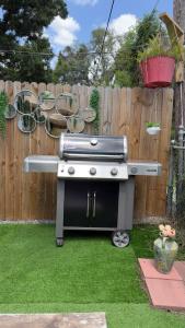 a barbecue grill in a yard next to a fence at Tropical Casita LaVida in Tampa
