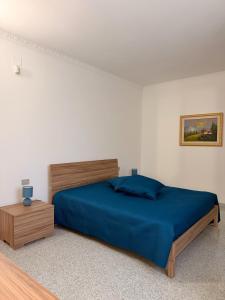 a bedroom with a bed with a blue comforter at Dimora Caratin' in Mattinata