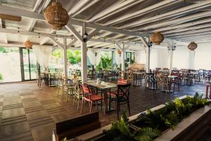 a dining room with tables and chairs and windows at Vila Sunce Village Resort Konjic in Konjic
