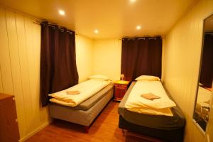 a small room with two beds and a window at Comfort Apartment in Tromsø