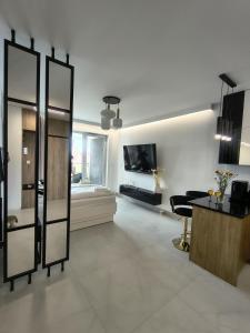 a large living room with a table and a tv at Mazury Glam Studio in Giżycko